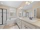 Bright bathroom featuring double vanity, soaking tub, walk-in shower, and large mirror at 6420 Agave Ave, Castle Rock, CO 80108