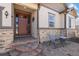 Inviting front porch seating area featuring stone accents, a well-manicured lawn, and a charming entry door at 6420 Agave Ave, Castle Rock, CO 80108
