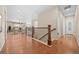 Hallway with hardwood floors, wood railing, and view to living room at 6420 Agave Ave, Castle Rock, CO 80108