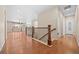 Hallway with gleaming hardwood floors, staircase with decorative railings, and ample natural light at 6420 Agave Ave, Castle Rock, CO 80108