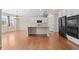 Kitchen features white cabinetry, a large island with seating, stainless steel appliances, and hardwood floors at 6420 Agave Ave, Castle Rock, CO 80108