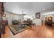 Open-concept living room featuring hardwood floors, plush seating, a ceiling fan, and a fireplace at 6420 Agave Ave, Castle Rock, CO 80108