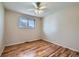 Bedroom with hardwood floors, ceiling fan, and a window overlooking the landscape at 1060 S Coffman St, Longmont, CO 80501