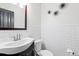Bright half bathroom featuring white subway tile, modern fixtures, and stylish wall decorations at 9432 La Quinta Way, Lone Tree, CO 80124