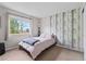 Bright bedroom featuring a cozy bed, modern wallpaper, and a sunlit window at 9432 La Quinta Way, Lone Tree, CO 80124