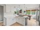A bright kitchen with a gas range, kitchen island and hardwood floors open to a dining room with great natural light at 9432 La Quinta Way, Lone Tree, CO 80124