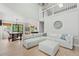 Open concept living room with tall ceilings, light hardwood floors and views to the kitchen at 9432 La Quinta Way, Lone Tree, CO 80124
