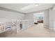 Bright loft area with neutral walls, plush carpet and staircase entrance to a cozy bedroom with view to mature trees at 9432 La Quinta Way, Lone Tree, CO 80124
