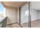 Balcony with sliding glass door and view into a gray, wood-floored room at 10722 E Exposition Ave # 314, Aurora, CO 80012