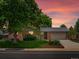 Charming brick house with a well-manicured lawn and mature trees at sunset at 945 Emerald St, Broomfield, CO 80020