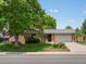 Charming brick house with a well-manicured lawn and mature trees at 945 Emerald St, Broomfield, CO 80020