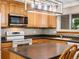 The kitchen features wood cabinetry, solid countertops, a window, and stainless steel appliances at 945 Emerald St, Broomfield, CO 80020