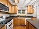 Bright kitchen with oak cabinets, modern appliances, decorative tile backsplash and dark countertops at 945 Emerald St, Broomfield, CO 80020