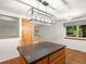 Kitchen island with seating and a modern light fixture, with wood floors, view to exterior window at 945 Emerald St, Broomfield, CO 80020