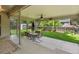 Covered patio with an outdoor dining area, ceiling fan, and a view of the landscaped backyard at 945 Emerald St, Broomfield, CO 80020