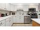 Bright kitchen features white cabinets, quartz countertops, and stainless steel appliances at 11368 Lamar St, Westminster, CO 80020