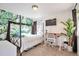 Bright bedroom with tropical wallpaper, a metal frame bed, and a cozy workspace with a desk at 13462 E Asbury Dr, Aurora, CO 80014