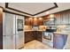 Modern kitchen with stainless steel appliances, including a large refrigerator and microwave, and granite counters at 13462 E Asbury Dr, Aurora, CO 80014