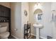 View of a half bathroom with a white pedestal sink, decorative mirror and cabinet storage at 27837 E 8Th Ave, Aurora, CO 80018