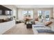 Bright living room with carpet, a sectional sofa, large windows and a TV at 27837 E 8Th Ave, Aurora, CO 80018
