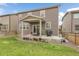 Spacious backyard with a covered patio, grill, outdoor seating, and lush green lawn at 6484 N Ceylon Ct, Denver, CO 80249