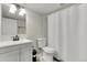Cozy bathroom featuring a sink, toilet, and a shower with a white shower curtain at 6484 N Ceylon Ct, Denver, CO 80249
