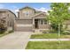 Charming two-story home with a two-car garage, inviting front porch with stone accents and landscaped front yard at 6484 N Ceylon Ct, Denver, CO 80249