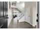 Inviting foyer with wood floors, white staircase, and an open view into the living room at 6484 N Ceylon Ct, Denver, CO 80249