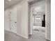 Hallway leading to a bedroom, with carpeted floors and a tray ceiling feature at 6484 N Ceylon Ct, Denver, CO 80249