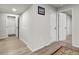 Hallway featuring laminated wood flooring, a framed print, and closet and room access at 6484 N Ceylon Ct, Denver, CO 80249