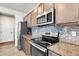 Kitchen with granite countertops and stainless steel appliances at 6484 N Ceylon Ct, Denver, CO 80249