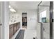 Bright main bathroom featuring double sinks, lots of counter space, and a glass enclosed shower at 6484 N Ceylon Ct, Denver, CO 80249