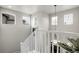The staircase has a modern white railing, with natural light, and a decorative pendant light at 6484 N Ceylon Ct, Denver, CO 80249