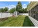 Landscaped backyard with well-maintained lawn, storage shed, and white picket fence, offering a serene outdoor space at 105 Dudley St, Lakewood, CO 80226
