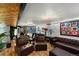Finished basement living area with bar, sofa, and unique architectural features, including textured walls and stylish decor at 105 Dudley St, Lakewood, CO 80226