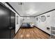 Bedroom showcasing textured white walls, modern light fixture, wood floors, and a single bed frame at 105 Dudley St, Lakewood, CO 80226