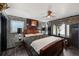 Main bedroom featuring a draped window, ceiling fan, bedside table, and tiled accent walls at 105 Dudley St, Lakewood, CO 80226
