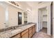 Bathroom includes double sinks with granite counters, modern lighting, and access to a walk-in closet at 12853 E 108Th Ave, Commerce City, CO 80022