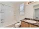 Bathroom with a tub and shower combo plus a granite vanity, toilet, and a window at 12853 E 108Th Ave, Commerce City, CO 80022