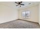 The primary bedroom offers comfortable carpet flooring, a lighted ceiling fan, and bright natural light at 12853 E 108Th Ave, Commerce City, CO 80022