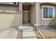 Close up of covered front porch of home with security system, painted trim and concrete steps at 12853 E 108Th Ave, Commerce City, CO 80022