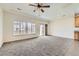 Bright living area with plush carpet, large windows, and sliding glass doors leading to the backyard at 12853 E 108Th Ave, Commerce City, CO 80022