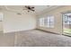 Bright living area with plush carpet, large windows, and sliding glass doors leading to the backyard at 12853 E 108Th Ave, Commerce City, CO 80022