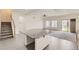 Bright open-concept living room featuring a large island, modern flooring, and access to the backyard at 12853 E 108Th Ave, Commerce City, CO 80022