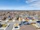 An aerial view of a single Gathering home nestled in a neighborhood with mountain views on a sunny day at 187 Cerillos St, Brighton, CO 80601