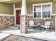 Inviting front porch featuring stone columns and comfortable seating, perfect for relaxing at 187 Cerillos St, Brighton, CO 80601