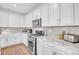 Updated kitchen featuring white cabinetry, granite countertops, stainless appliances, and modern backsplash at 187 Cerillos St, Brighton, CO 80601