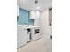 Bright laundry room features a modern washer and dryer, storage cabinets, and accent wall at 187 Cerillos St, Brighton, CO 80601