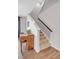 Carpeted stairway with wood accents next to wood flooring and a piano for decor at 187 Cerillos St, Brighton, CO 80601