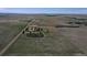 Property aerial view featuring a homestead surrounded by open fields and distant horizons, with a road crossing landscape at 7409 S County Road 157, Strasburg, CO 80136